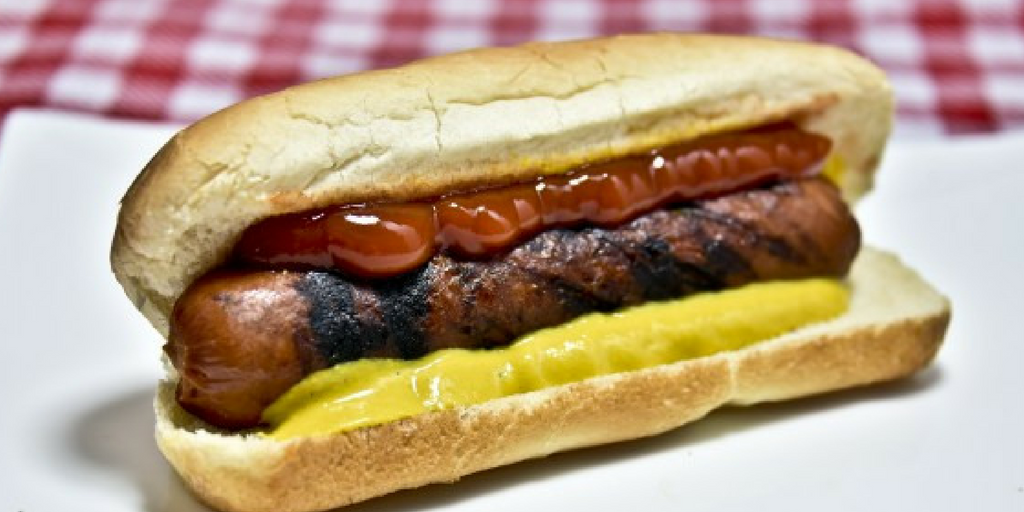 hotdog with bun covered in ketchup and mustard