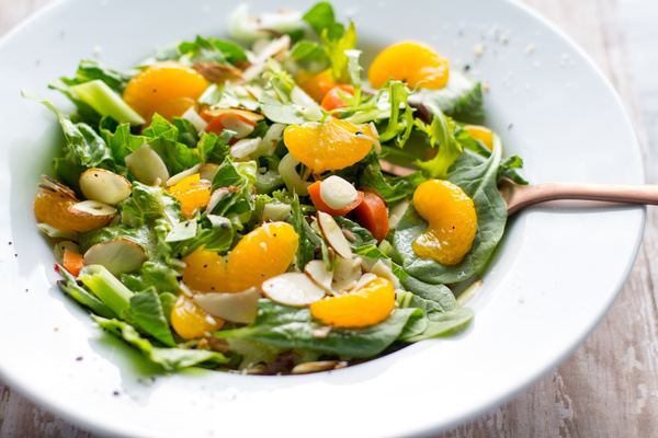Easy Mandarin Salad Recipe by Intentionally Eat with Cindy Newland in a white bowl with a bronze spoon