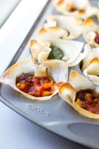 image of crunchy taco cups that are healthy by intentionally eat in a mini muffin tin with salsa and yellow peppers