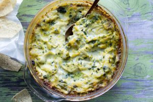 image of healthy spinach artichoke dip by intentionally eat with cindy newland in a glass bowl with a gold spoon
