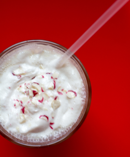 skinny peppermint vanilla vegan protein shake recipe with a straw and red background