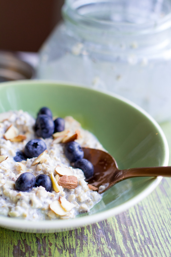 image of simple-overnight-oats by intentionally eat in a green bowl topped with blueberries and almonds