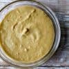 image of the creamiest cashew cheese by intentionally eat with Cindy Newland in a glass bowl on a chipped white painted board
