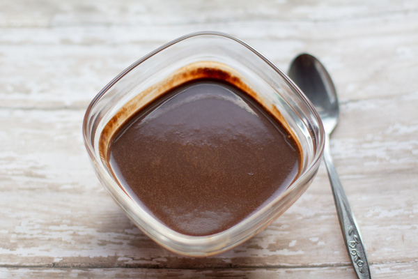 easy dairy free hot fudge sauce by cindy newland with intentionally eat in a glass bowl with a silver spoon