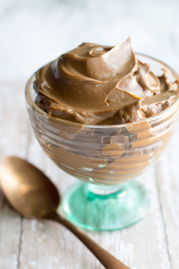 image of chocolate avocado pudding by intentionally eat with cindy newland in a glass dish with a gold spoon and green napkin for healthy plant-based summer desserts