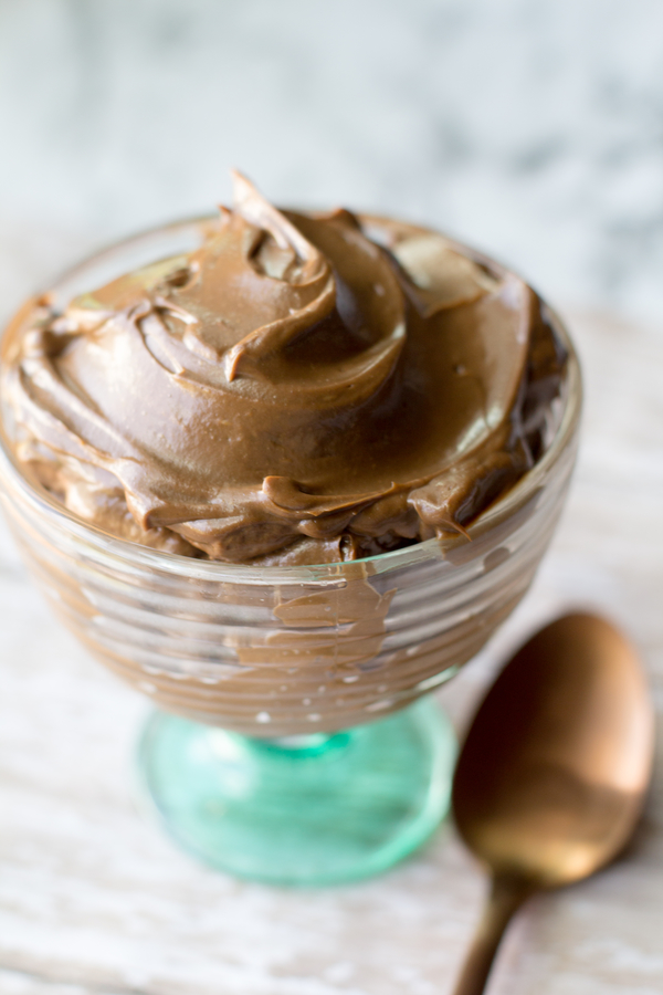 easy chocolate avocado pudding healthy dessert in a glass dish with a gold spoon