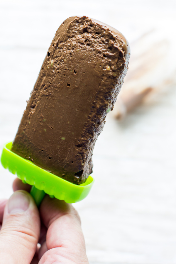 image of avocado fudgesicles by intentionally eat with cindy newland with a hand pulling the fudgesicle out of the container