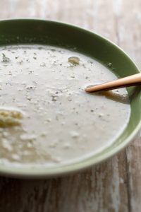 easy roasted cauliflower chowder by intentionally eat with cindy newland in a green bowl with a spoon