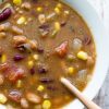 Skinny Taco Soup by intentionally Eat with Cindy Newland in a white bowl with a gold spoon