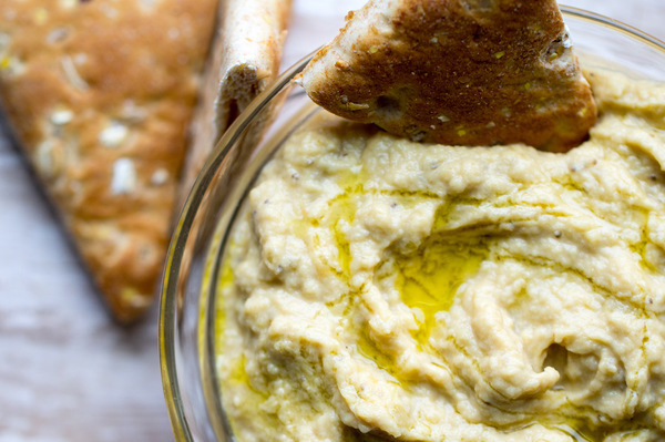 image of Easy Baba Ganoush-roasted eggplant dip by intentionally eat with Cindy Newland in a glass bowl with pita bread