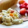 Creamy Potato Salad Oil Free by Intentionally Eat with Cindy Newland on a plate with a veggie dog, cherries and a gold fork
