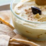 image of Velvety Oil Free Hummus by Intentionally Eat with Cindy Newland in a glass bowl surrounded by pita bread