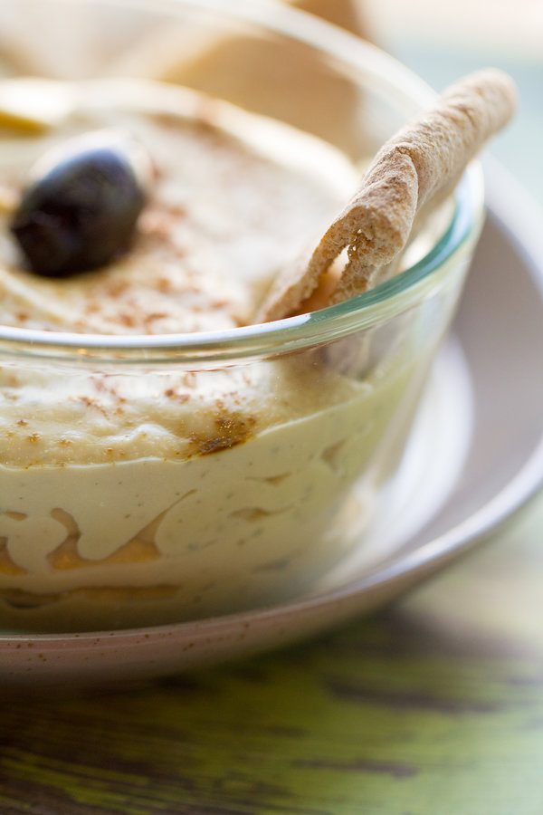 image of Velvety Oil Free Hummus by Intentionally Eat with Cindy Newland in a glass bowl surrounded by pita bread