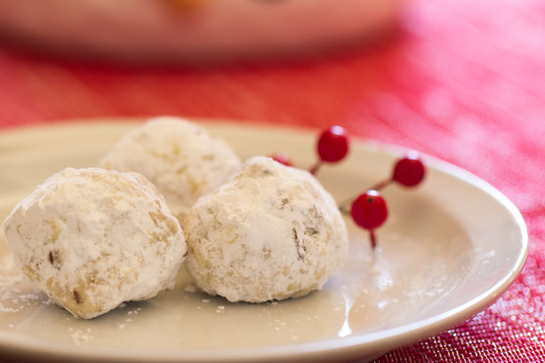 image of Healthy Snowball Cookies on a plate with red berries