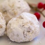 image of Healthy Snowball Cookies by Intentionally Eat with Cindy Newland on a plate with red berries