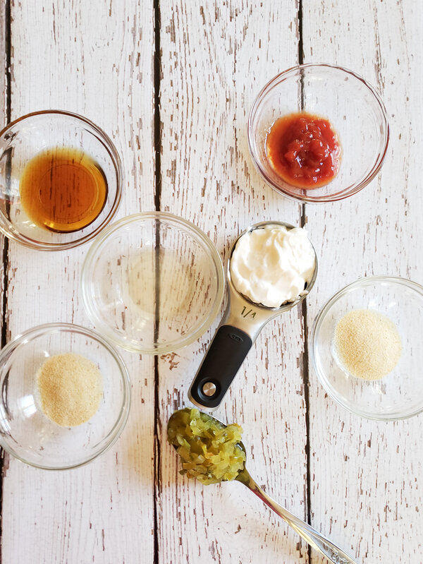 photo of vegan mayo, ketchup, maple syrup, garlic powder, onion powder, apple cider vinegar, and sweet pickle relish in small glass dishes, measuring cup, and a spoon