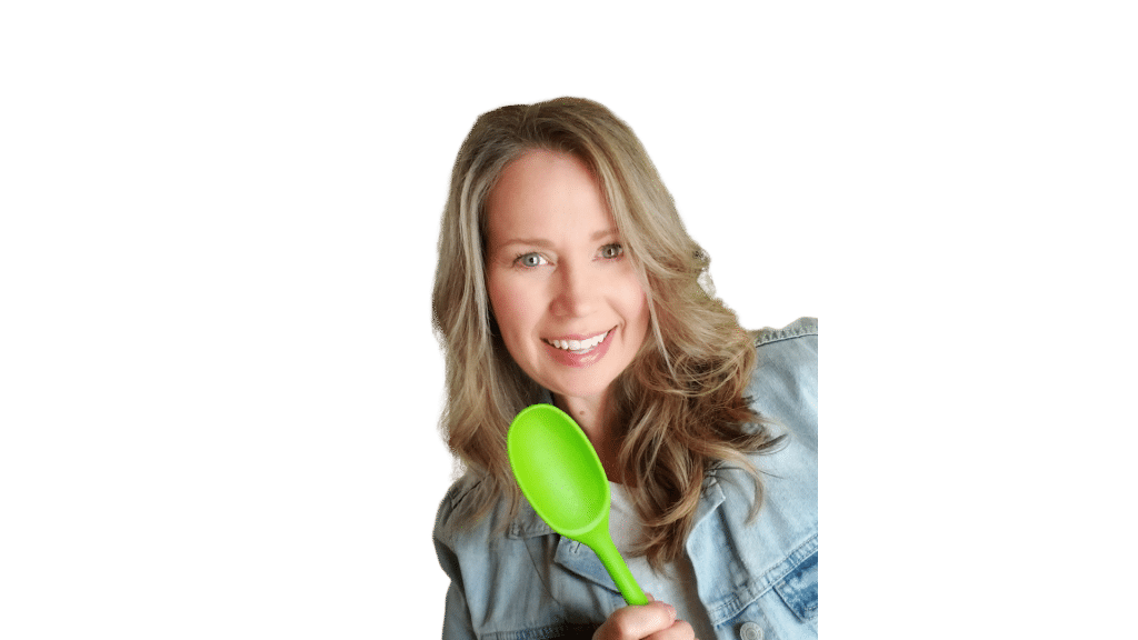 image of Cindy Newland from Intentionally Eat a plant based website, holding a green spoon and wearing a denim jacket