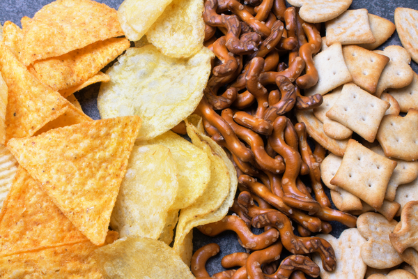 Vegan snack foods like chips, pretzels, and crackers for a vegan grocery list