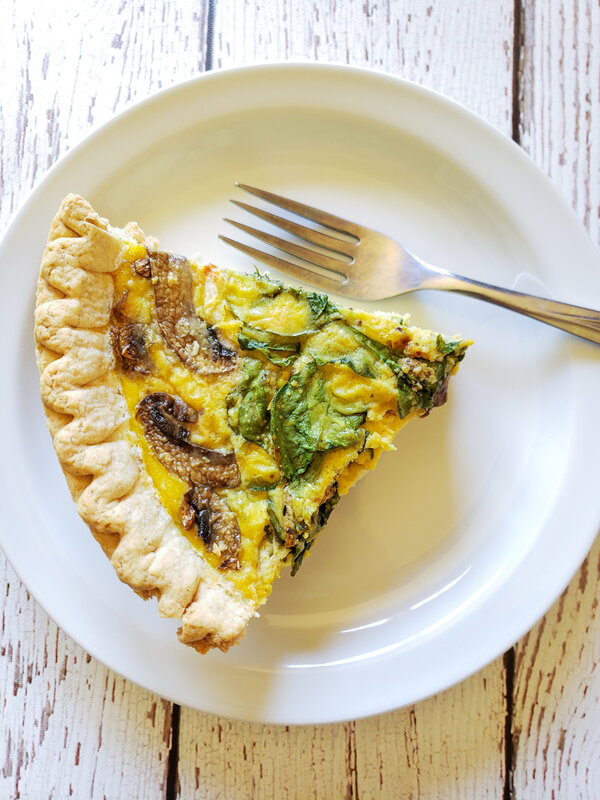 A slice of vegan quiche on a white plate with a fork.