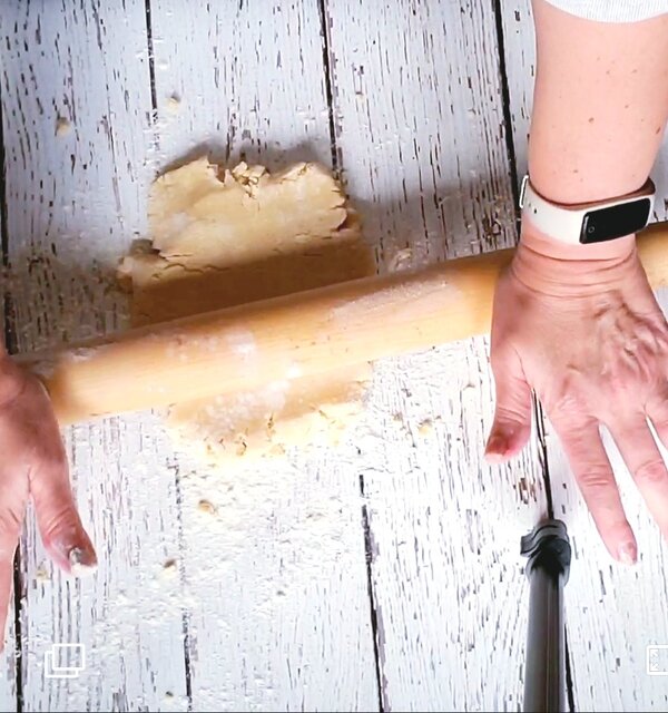 hands on a rolling pin rolling out easy vegan pie dough
