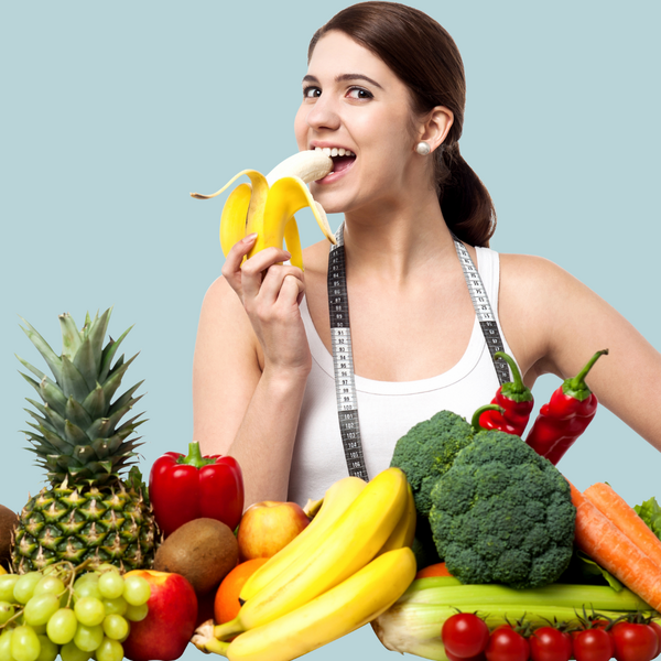 image of woman eating a banana surrounded by fruits and vegetables for a vegan diet