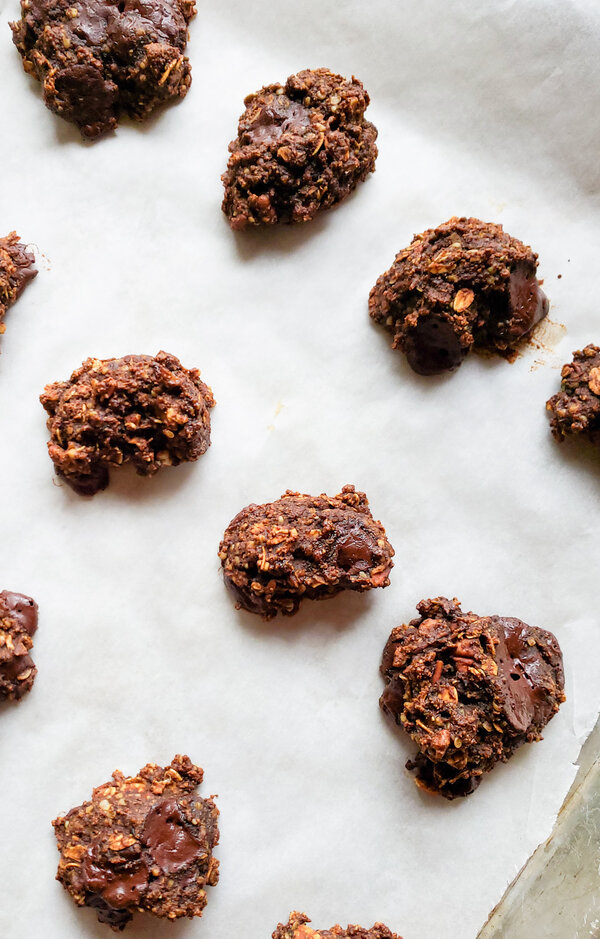 image of chewy oatmeal chocolate chip cookies on parchment paper.
