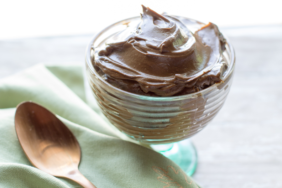vegan chocolate avocado pudding in a glass dish with a gold spoon