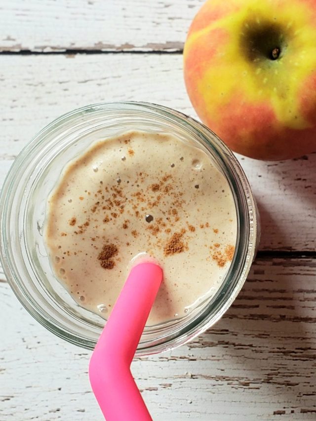 smoothie in a glass with an apple next to it