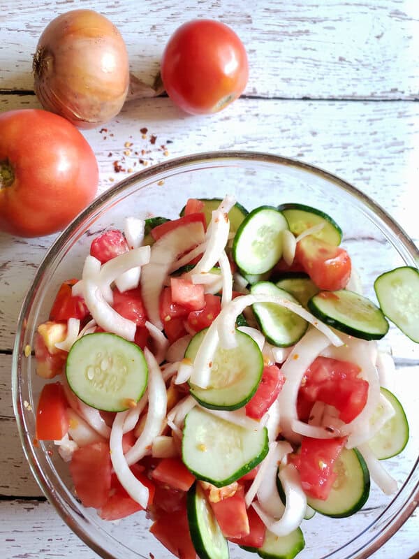 sliced tomatoes, onions, and cucumbers in a 3 ingredient salad