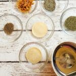assorted spices in bowls with a spice grinder