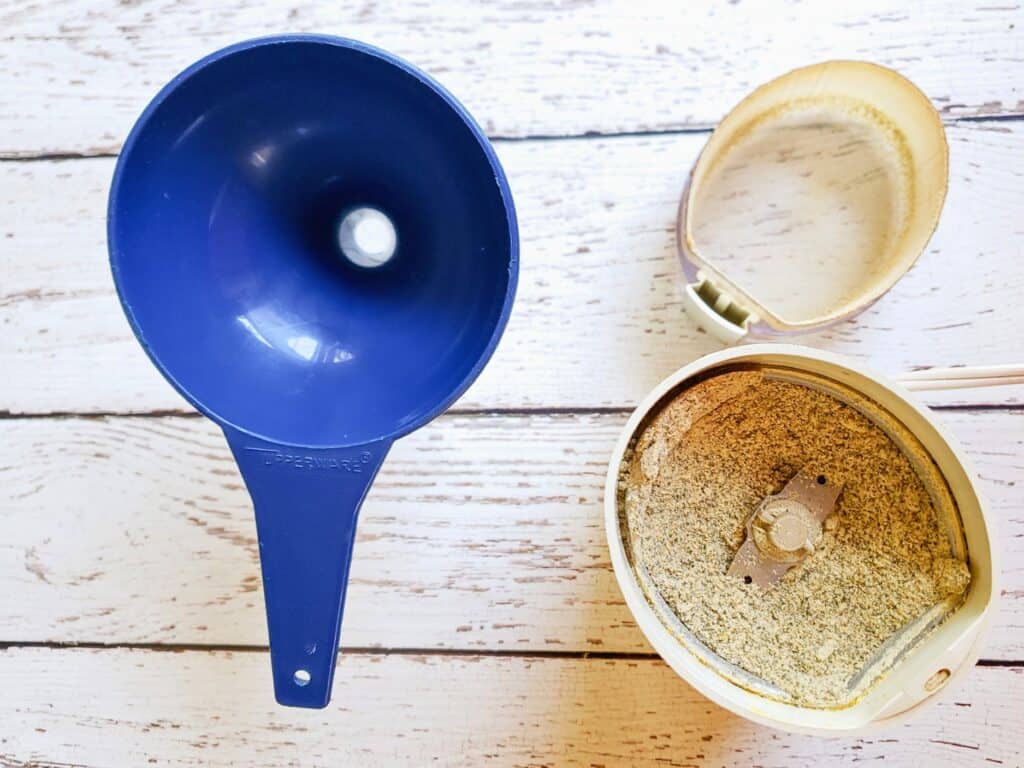 a spice grinder with spices and a funnel