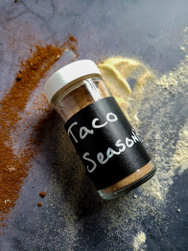 taco seasoning jar on top of spilled spices