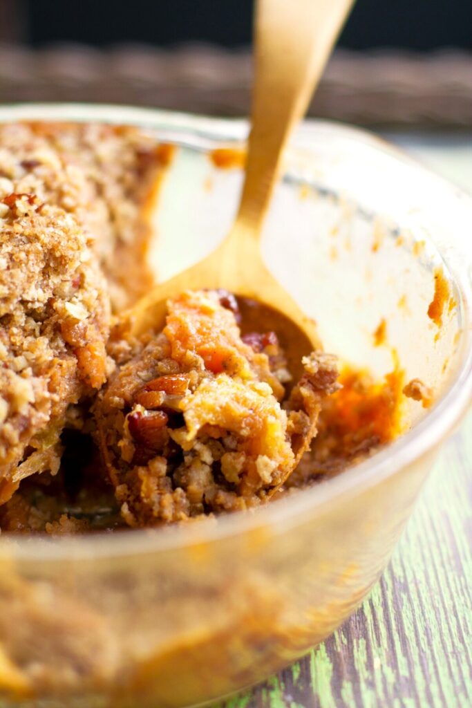 sweet potato casserole vegan gluten free no eggs in a glass dish with a wooden spoon