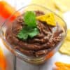 black bean dip in a glass bowl with peppers and tortilla chips