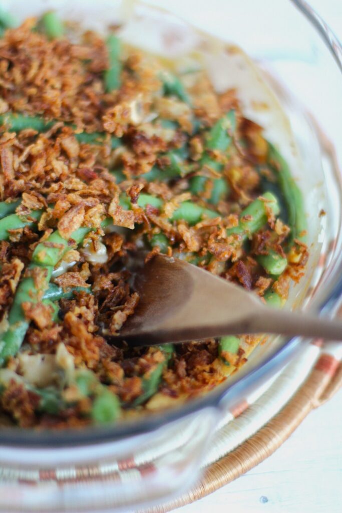 Green bean casserole with a wooden spoon