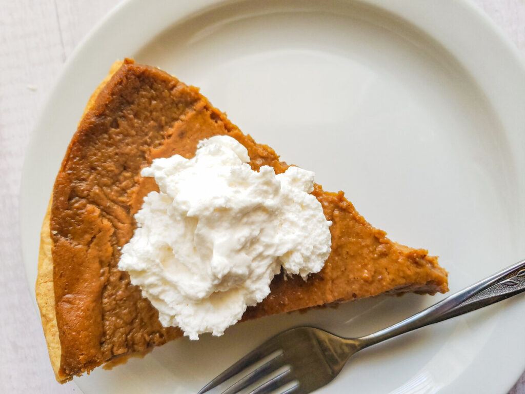 a slice of eggless sweet potato pie with dairy free whip cream