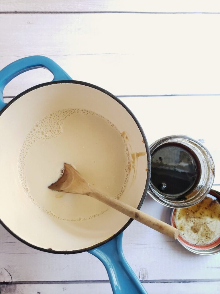 saucepan with non-dairy milk and a jar of gingerbread syrup