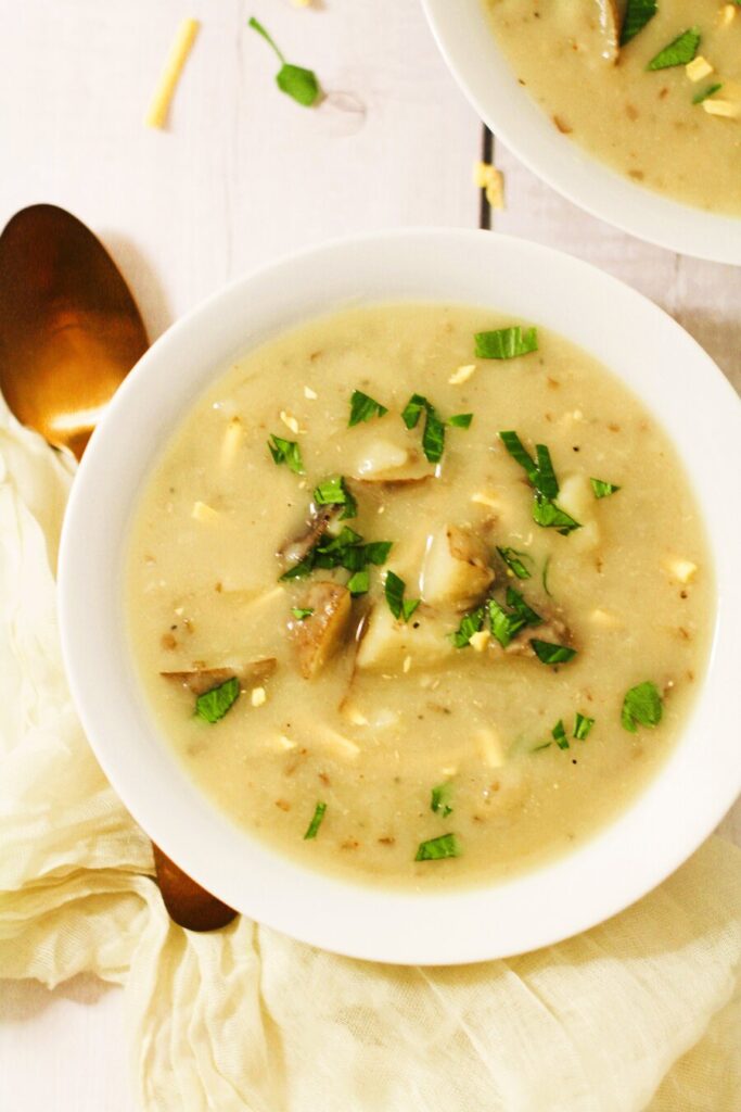 vegetarian potato soup recipe in a white bowl with gold spoon