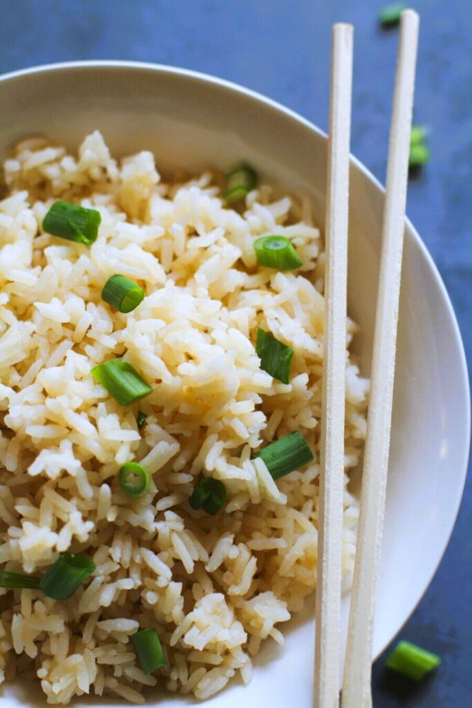 white rice in a bowl with chopsticks