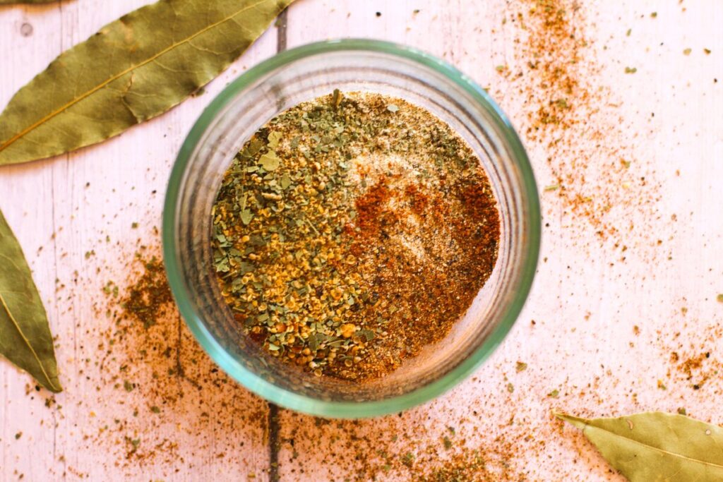 spice mix in glass dish with bay leaves
