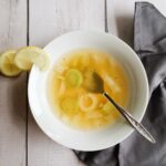 leek soup in a bowl with lemon and a napkin