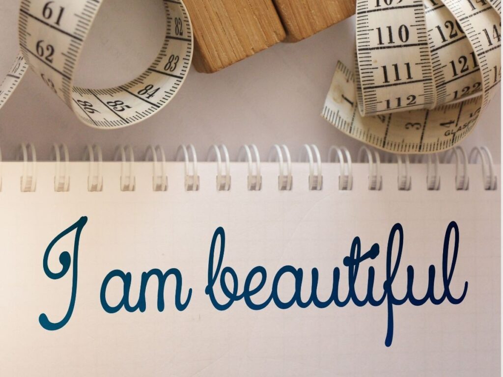 paper with the words I am beautiful surrounded by a measuring tape