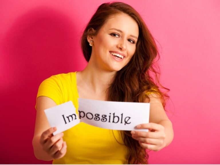 woman holding sign that says impossible and tearing the im off
