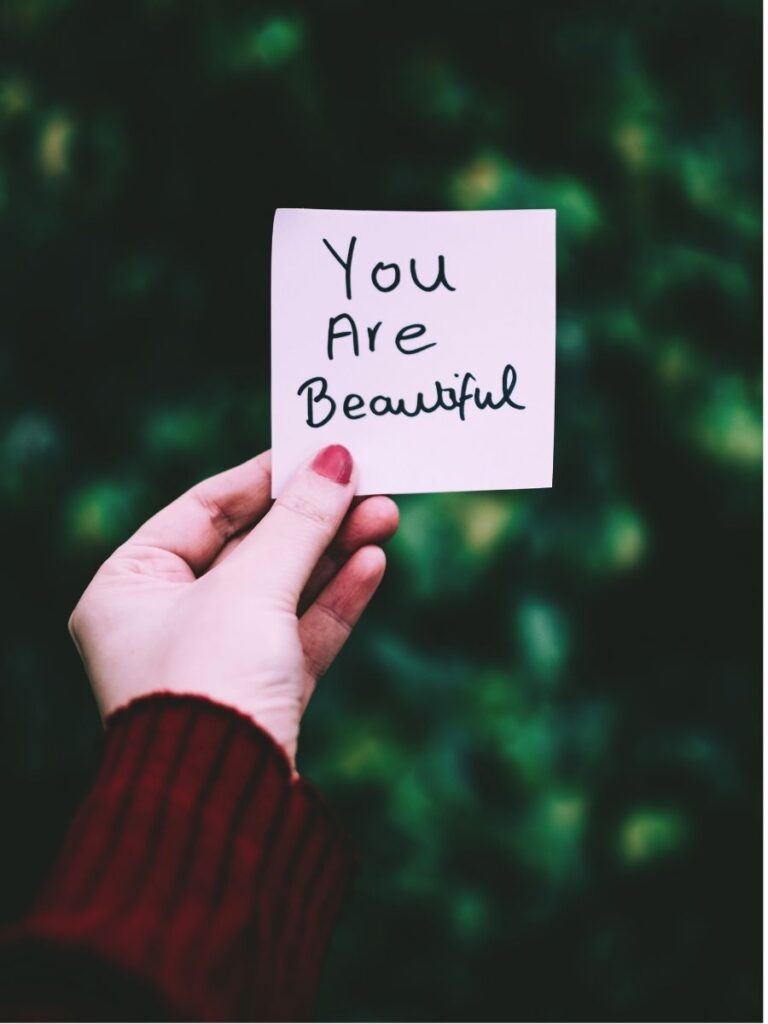 hand holding sticky note saying you are beautiful