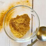 curry powder substitute in a small glass dish with a tablespoon