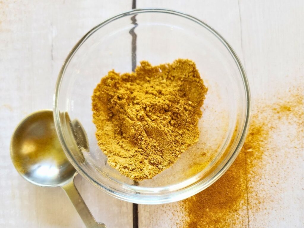 Curry powder substitute in a small glass dish with a tablespoon