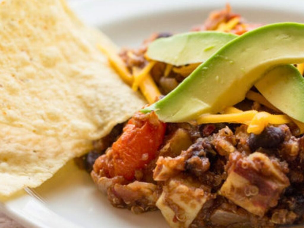 vegan quinoa casserole with avocado slices and tortilla chips