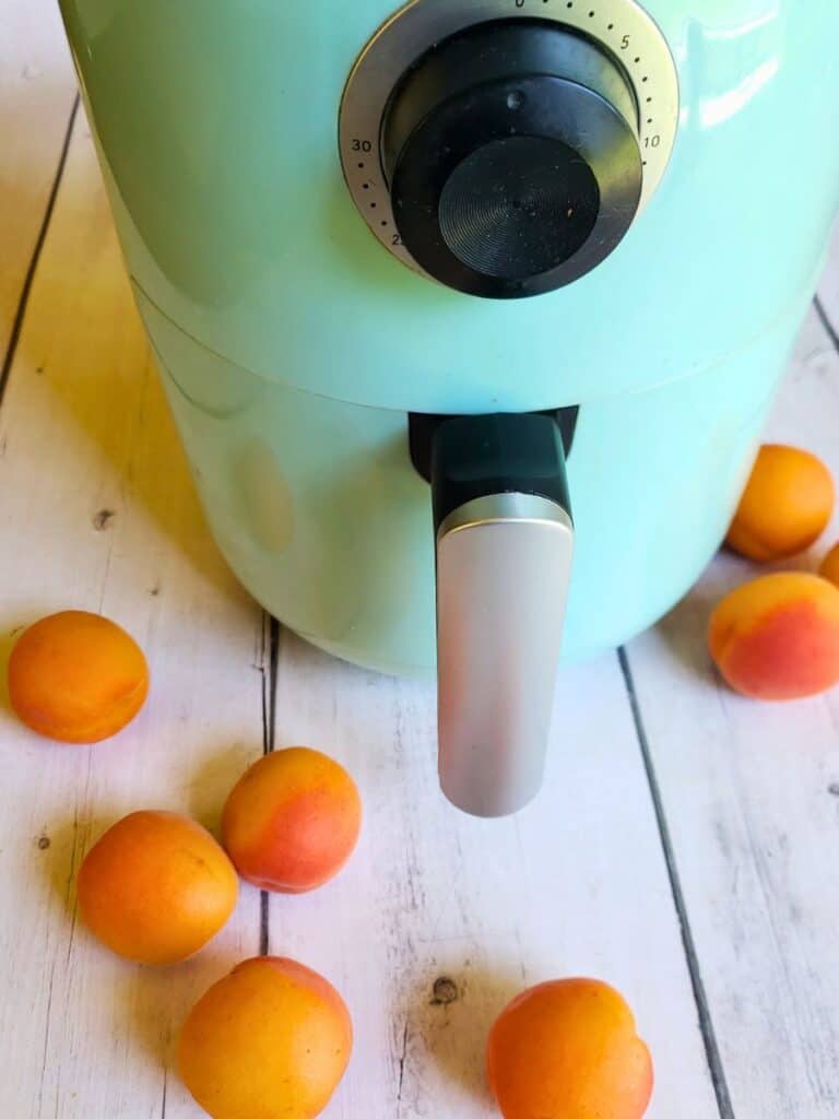 fresh apricots surrounding an air fryer