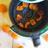 dried apricots in air fryer basket surrounded by fresh apricots