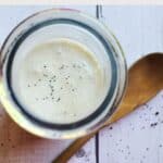 poppyseed dressing in a glass jar with a wooden spoon